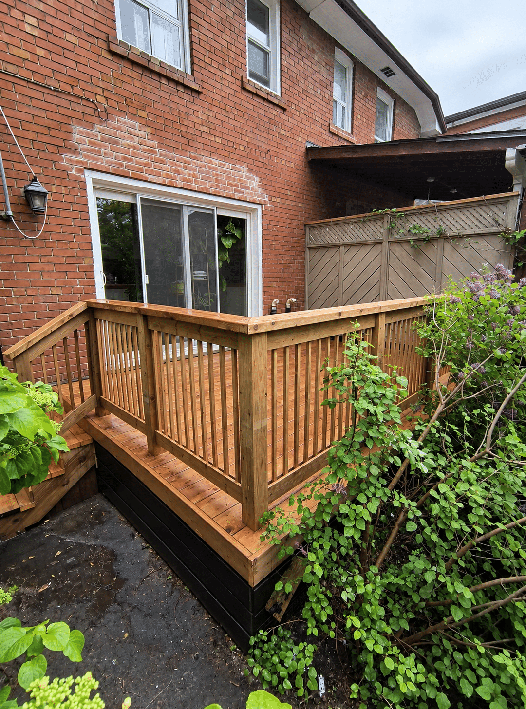 Wooden backyard deck construction with pressure-treated lumber railings and stairs